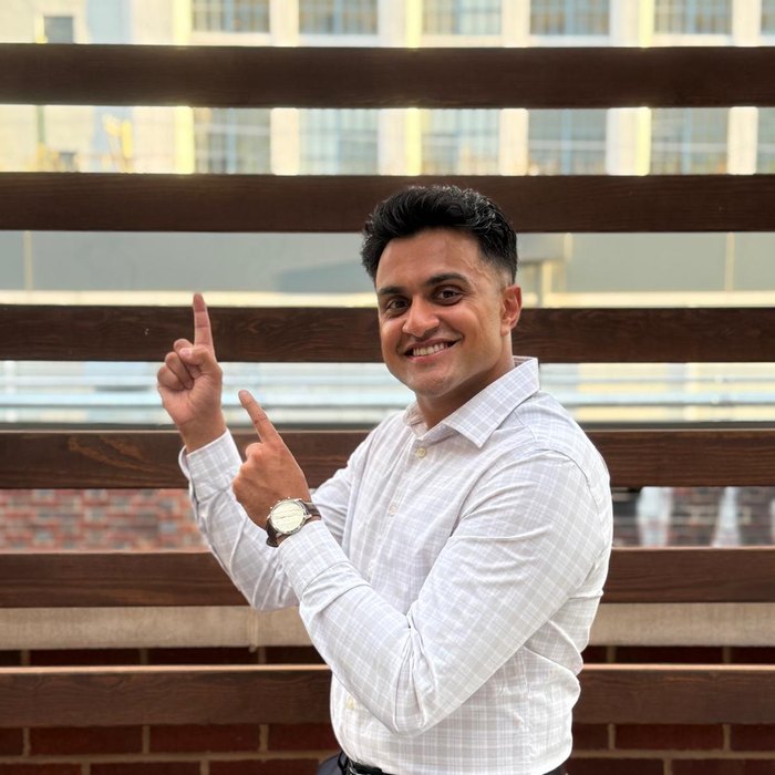 Kiran Aiyar pointing, mid-laugh.